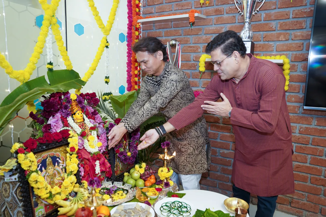Two Ripplrites making an offering at the Ganesh Chaturthi shrine